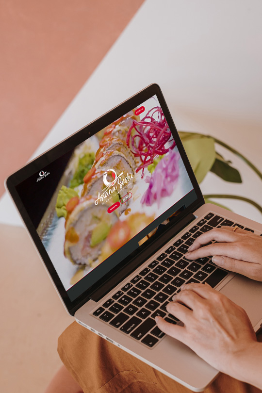 hands typing on a laptop while browsing asiana sushi website