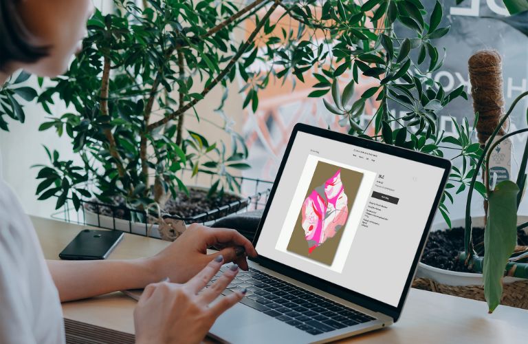 woman sitting in front of a laptop browsing Studio Parasto Backman shop